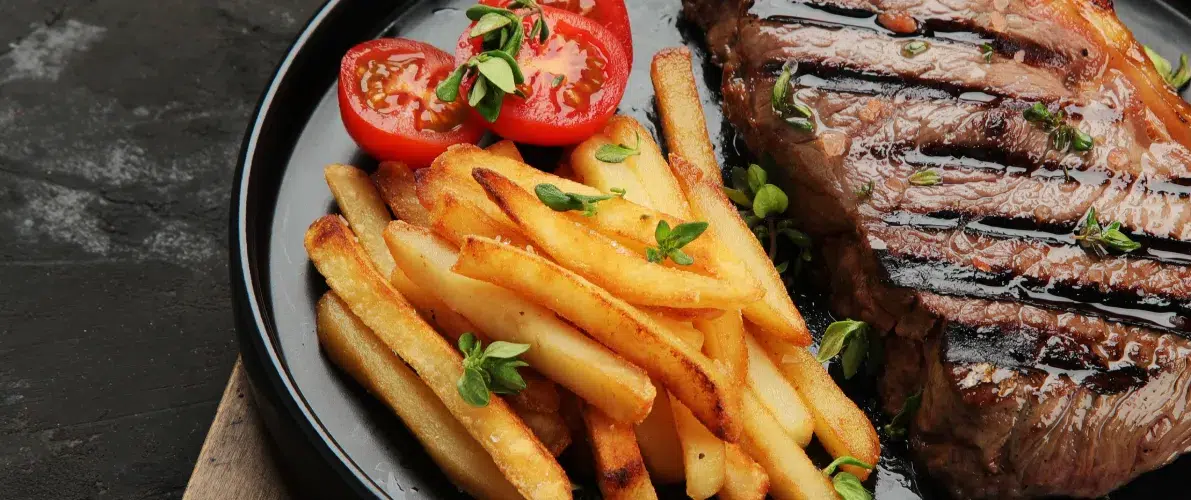Steak grillé avec frites et tomates